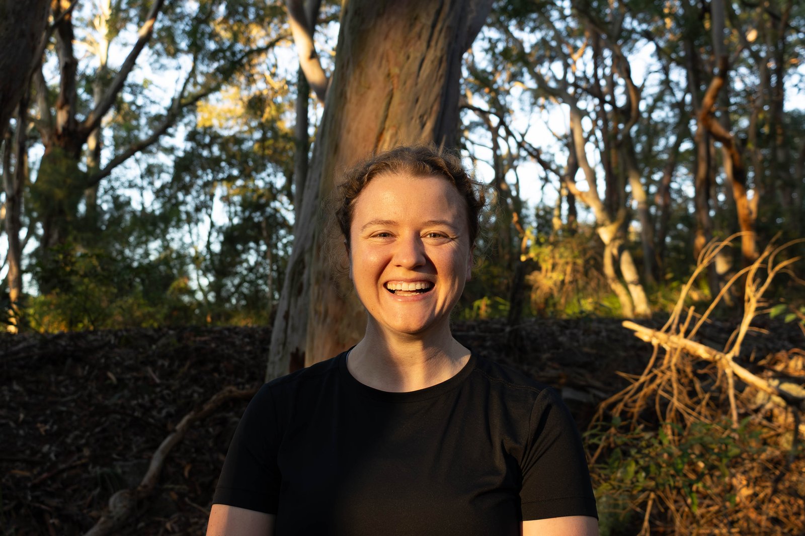 Sophie Lane, coach at Stronger Stride Coaching, smiling outdoors in front of a tree